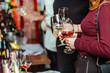 © Елена Нестерова - wine tasting: visitors stand near tables with tasting samples and hold glasses of wine.