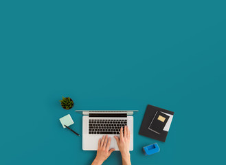 Man working on laptop in minimal workspace. Top view.	