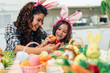 © hedgehog94 - Mother and her cute little daughter having fun in kitchen while preparing Easter eggs.
