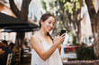 © Marcos - young latin woman messaging by phone wearing casual clothes in Mexico
