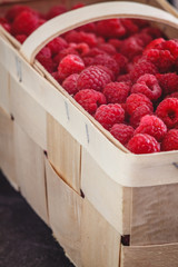 Sticker - bright juicy ripe red raspberries in a basket on a dark retro background