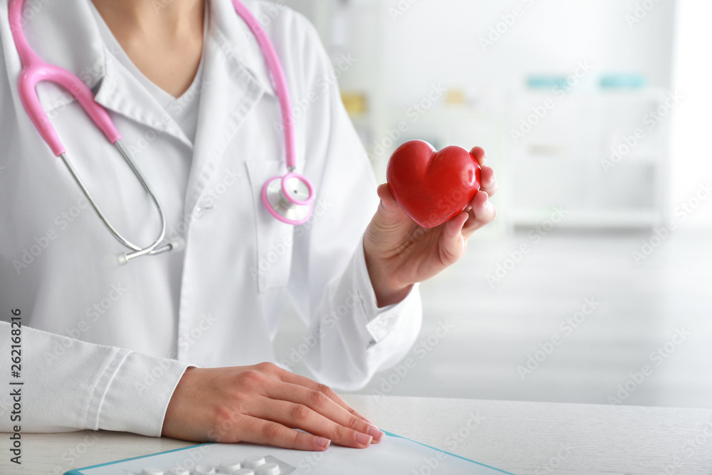 Cardiologist with red heart in clinic