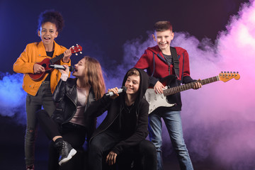 Wall Mural - Band of teenage musicians on dark background