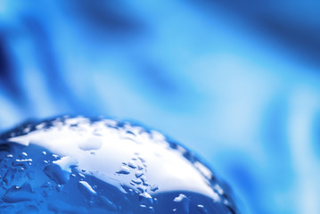 Wall Mural - Crystal ball with water drops. Glass ball with drops of water in abstract blue with rays of light and reflections.