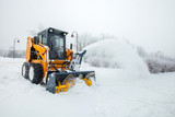 Fototapeta Uliczki - Snow removal works, snow removal machine in action