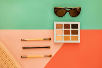 Wall Mural - Palette of shadows for a make-up and female trend accessories, on a geometrical multi-colored background, minimal, art, flatlay