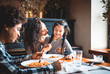 © leszekglasner - Happy african american family eating lunch together at restaurant and having fun
