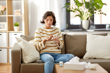 Wall Mural - people, health care and treatment concept - sad sick young woman taking medicine with water at home