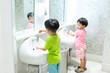 © No-Te - Happy brothers are washing hands in the kid toilet.