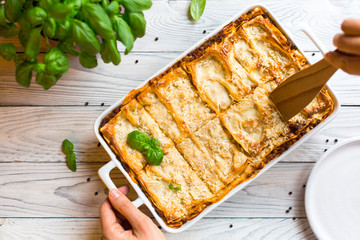 Canvas Print - Homemade baked lasagna emiliane made from traditional meat ragù cooked for 4 hours, béchamel sauce, flat pasta. Served in a casserole  and cut into single-serving square portions. Top view. 