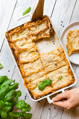 Canvas Print - Homemade baked lasagna emiliane made from traditional meat ragù cooked for 4 hours, béchamel sauce, flat pasta. Served in a casserole  and cut into single-serving square portions. Top view. 