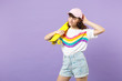 © ViDi Studio - Portrait of pensive teen girl in vivid clothes looking aside, holding yellow skateboard isolated on violet pastel background in studio. People sincere emotions, lifestyle concept. Mock up copy space.