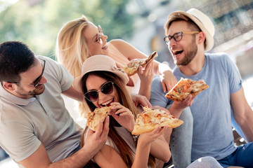 Canvas Print - Friends having fun and eating pizza in the city