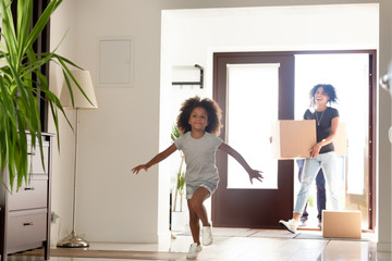 Wall Mural - Happy African American family with cardboard boxes in new home