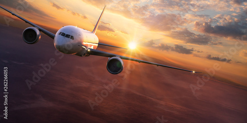 Commercial airplane jetliner flying above dramatic clouds. Fototapet