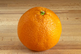 Fototapeta Sawanna - Isolated orange on a wooden board