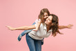© ViDi Studio - Woman in light clothes have fun with cute child baby girl. Mother, little kid daughter isolated on pastel pink wall background, studio portrait. Mother's Day, love family, parenthood childhood concept