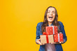 © denis_vermenko - Young smiling model hold gift box. Woman isolated on yellow background.