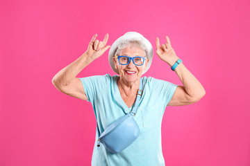 Portrait of cool grandmother on color background