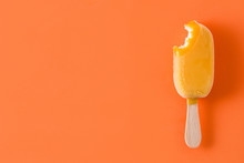 Bitten Orange Popsicle Pattern On Orange Background. Top View. Copyspace