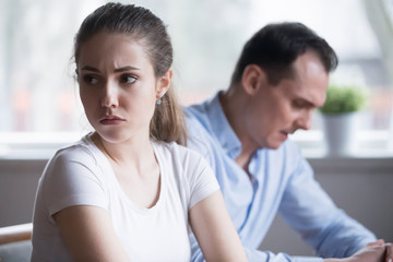 Wall Mural - Millennial couple after fight at home ignoring each other