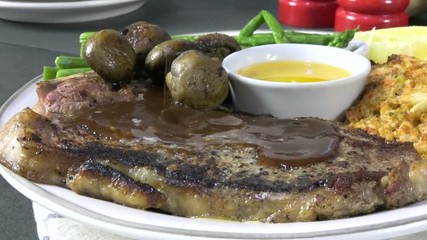 Canvas Print - Pouring steak sauce on a gourmet rib steak, slow motion