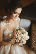 Stylish bouquet of pink and white flowers in the hands of the beautiful model girl in trendy wedding dress