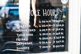 Fototapeta Łazienka - store hours written on glass