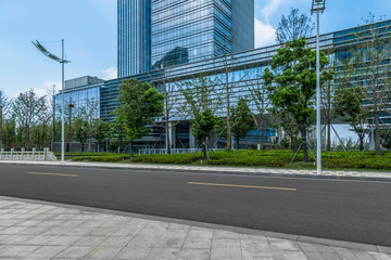 Wall Mural - empty asphalt road near glass office building.