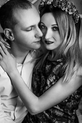 happy stylish couple hugging and sitting  on background of luxury interior in studio, black white photo