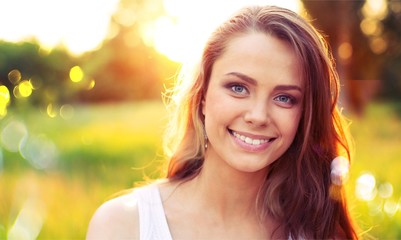 Young woman on field under sunset light