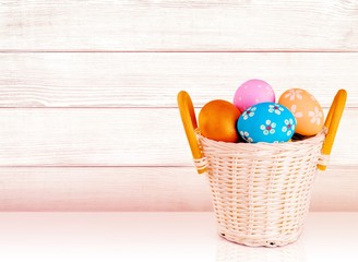 Canvas Print - Easter basket filled with colorful eggs on a white background