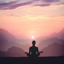 Man Meditating On High Mountain In Sunset Background