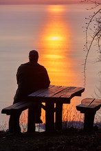 Man Locking At The Lake Balaton Of Hungary In Sunset Light