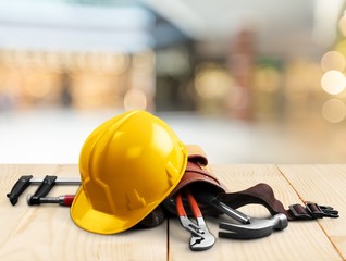 Wall Mural - Yellow helmet with equipment on wooden table background