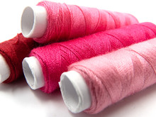 Sewing Threads In Pink Arranged In A Row, Isolated On White Background