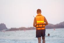Asian Lifeguard Walking On The Beach