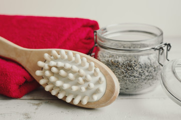 Wooden brush for body massage, scrub and red cotton towel. Dry body massage and skin exfoliating. Body care and spa treatment