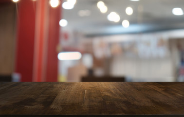 Empty dark wooden table in front of abstract blurred bokeh background of restaurant . can be used for display or montage your products.Mock up for space.