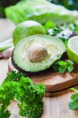 Sticker - Green fruit and vegetable - wooden board with green food  ingredients: garlic, avocado, lime, mint, cilantro, leek, green chili peppers.