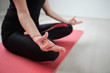 © chika_milan - Close up of woman sitting on the mat in lotus posture.