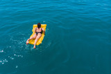 Fototapeta Do akwarium - young woman swimming in blue azure water