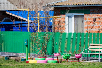 Colorful flowerbeds made of several old car tires