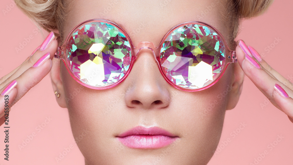 Portrait of Beautiful young Woman with Colored Glasses. Beauty Fashion. Perfect Make-up. Pink Nails Manicured. Colorful Decoration. Holographic sunglasses. Coral color - obrazy, fototapety, plakaty 