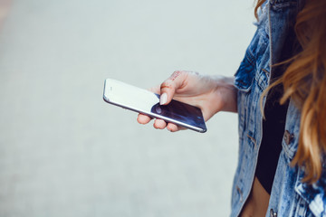 Close up of women's hands holding cell telephone with blank copy space scree for your advertising text message or promotional content, hipster girl watching video on mobile phone during coffee break