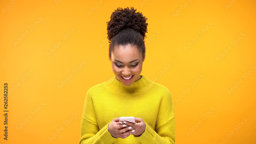 Smiling African-American woman chatting on smartphone, modern technology, app - obrazy, fototapety, plakaty 