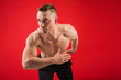 © Alexandr - handsome young man in athletic uniform on a red background in the pose of a runner