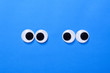 Googly eyes: Two pair strabismus and squint mad googly eyes next to each other on a blue background.