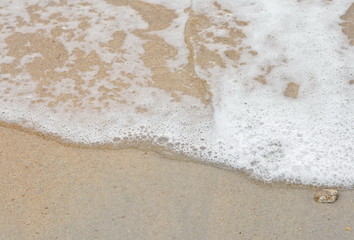 Beautiful soft waves of Blue Ocean with Sandy Beach Background close up. Sea sand wallpaper