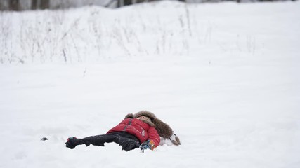 Wall Mural - Playful child play with snow, little boy with big fur cap  have fun, winter